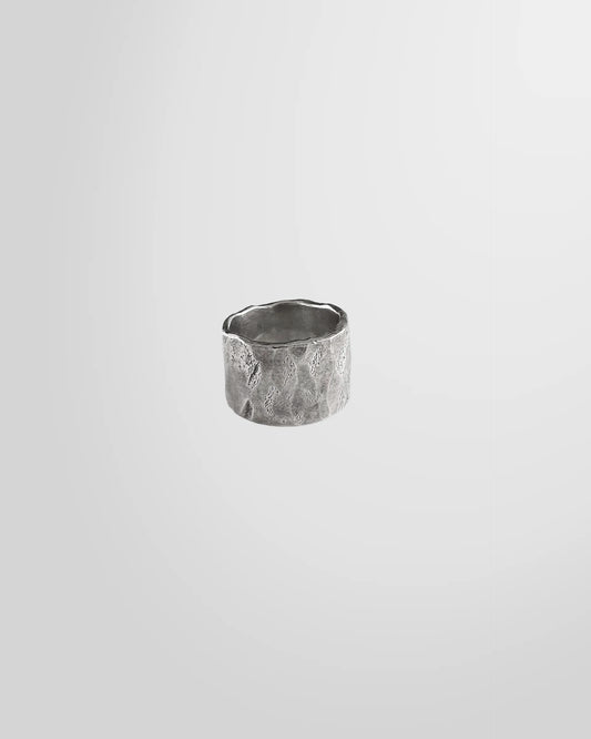 Front view of the Johnny Ramli Forged Band Ring in oxidised sterling silver, showing its irregular shape.
