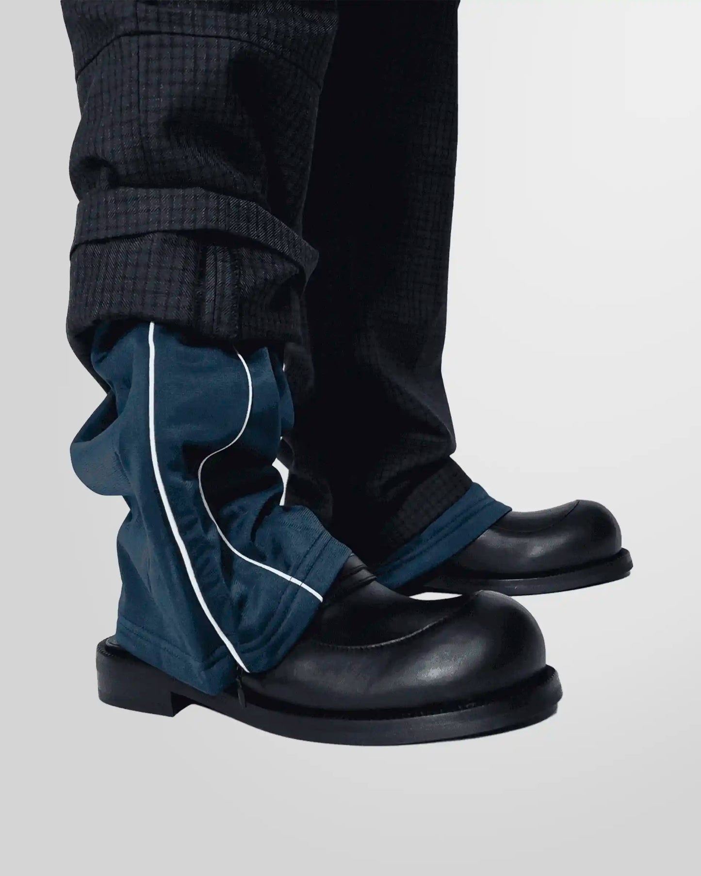 Close-up of the unique sports-inspired hem on the Martine Rose navy check trousers.