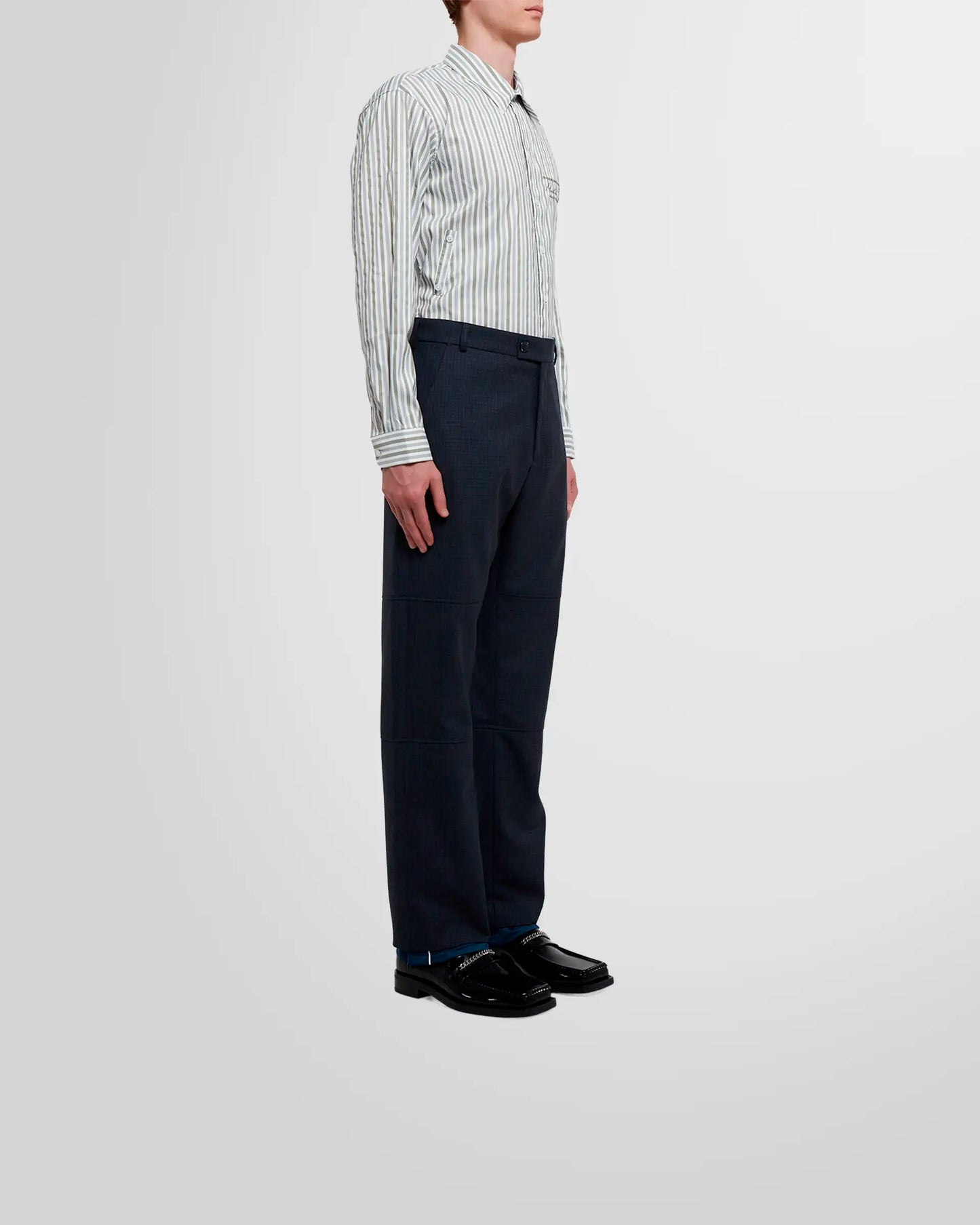 Side view of a model wearing Martine Rose Sports Hem Trousers in navy check.