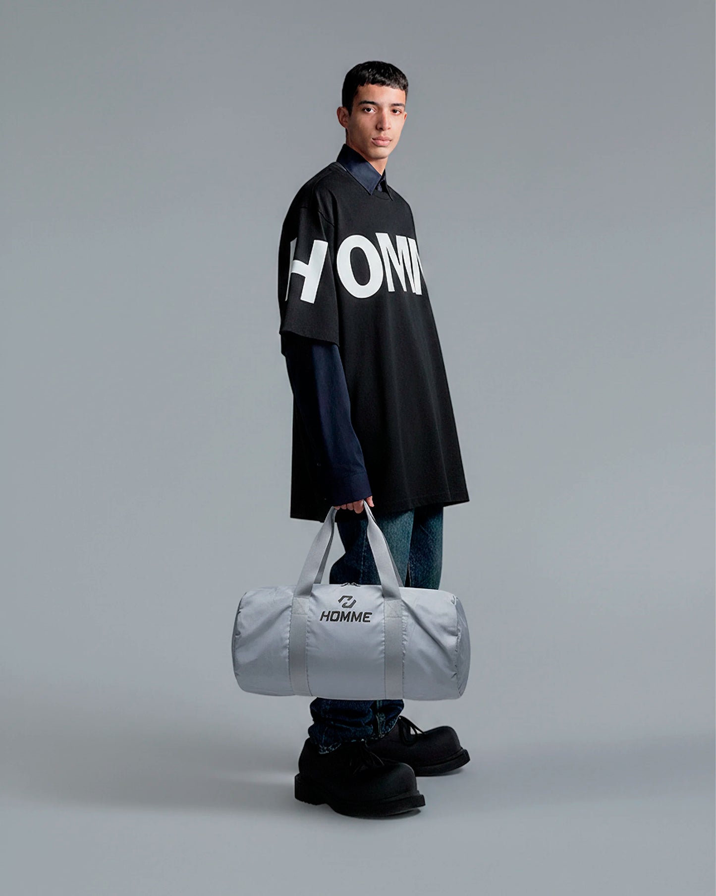 Model carrying the Not Guilty Homme sport bag, demonstrating its scale and function as a modern gym accessory.