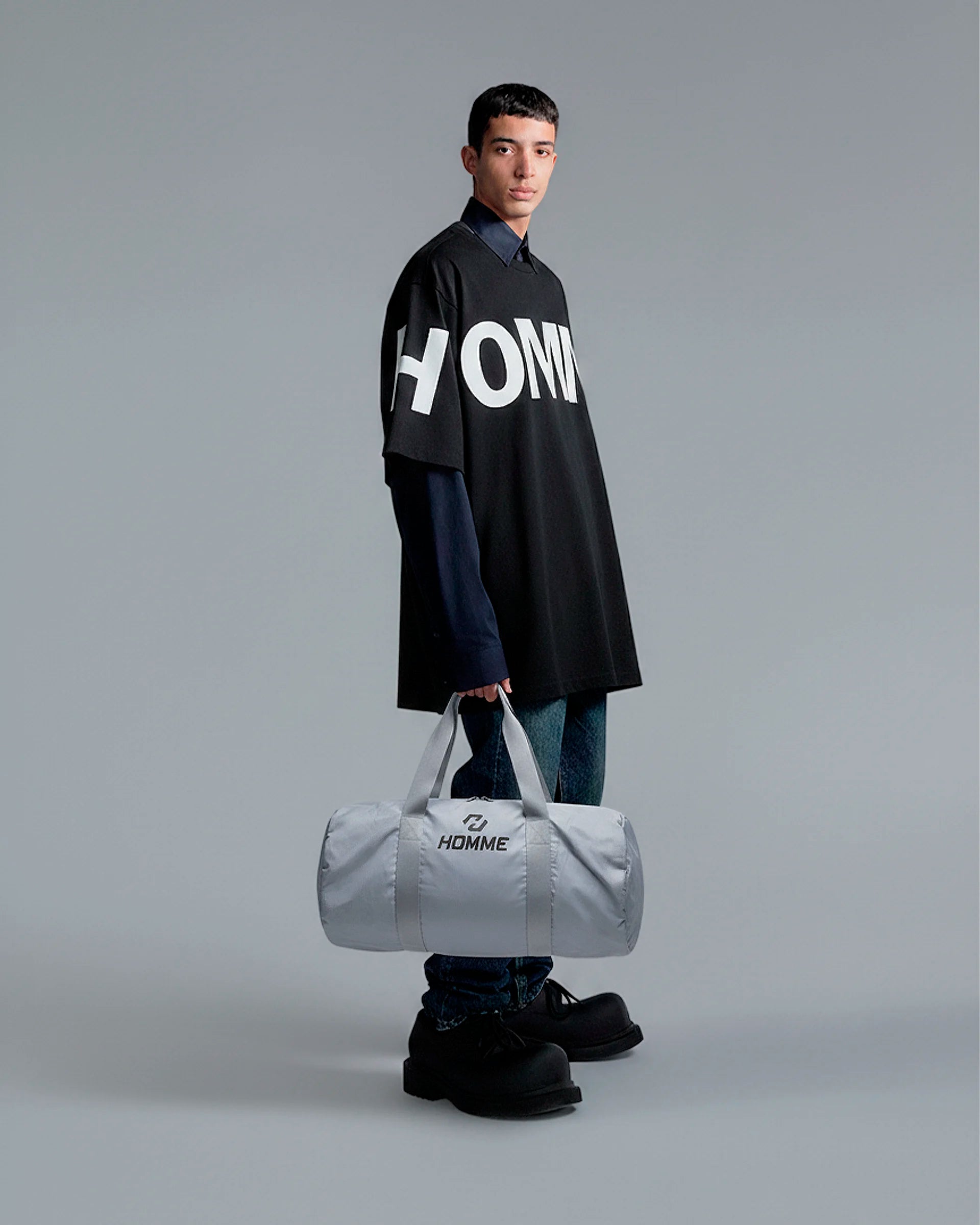 Model carrying the Not Guilty Homme sport bag, demonstrating its scale and function as a modern gym accessory.
