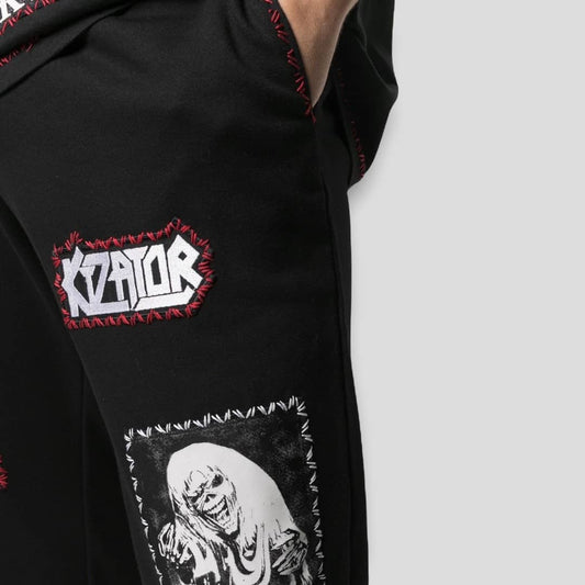 A close-up of the intricate patchwork and embroidered logo details on the KTZ track pants.