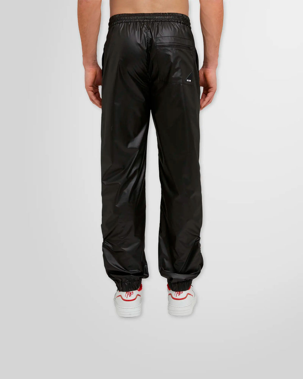 Back view of MSGM Black Nylon Track Pants showcasing rear pocket with logo patch and elastic cuffs.