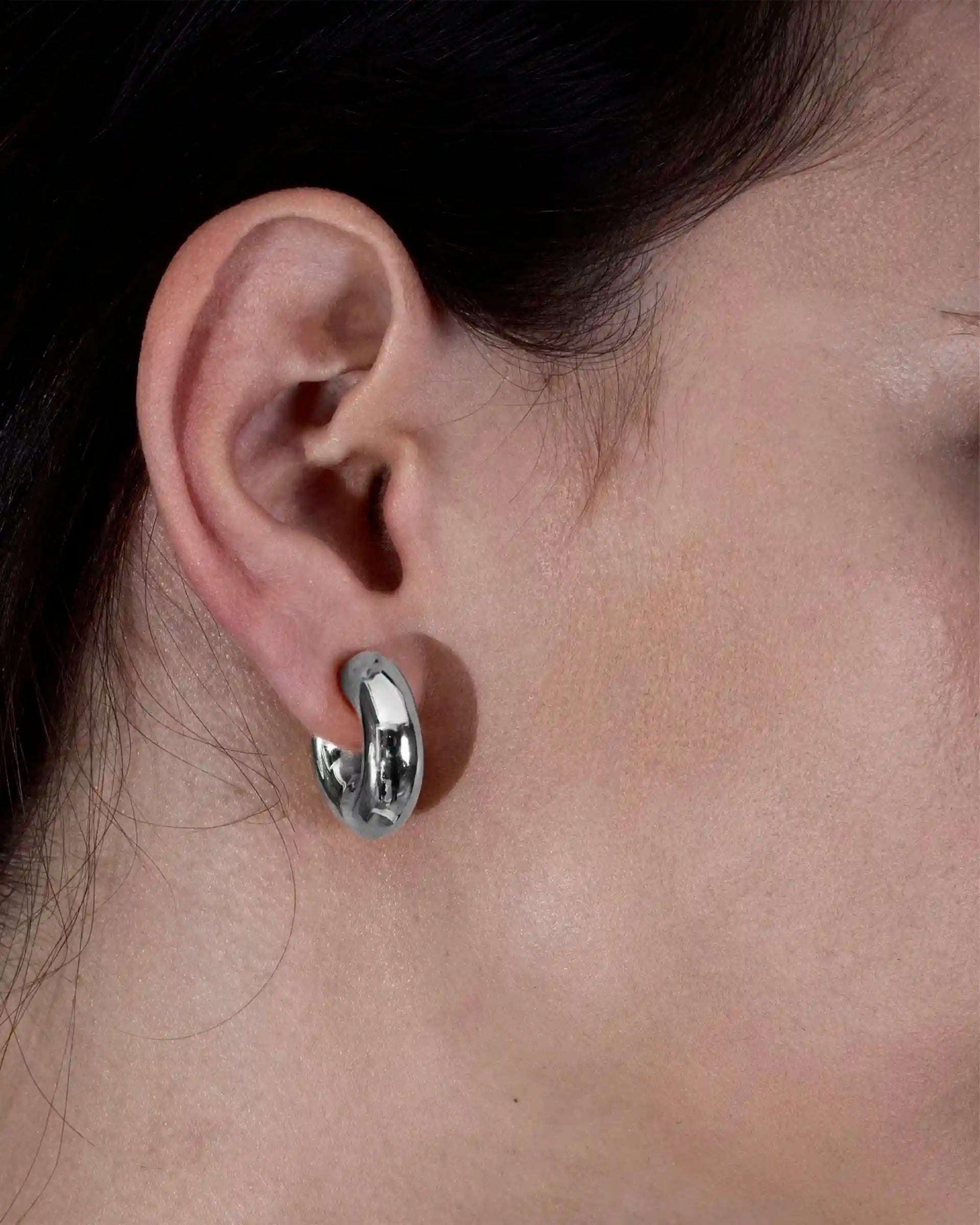 Alan Crocetti Clear Blown Peekaboo single earring in silver on model.