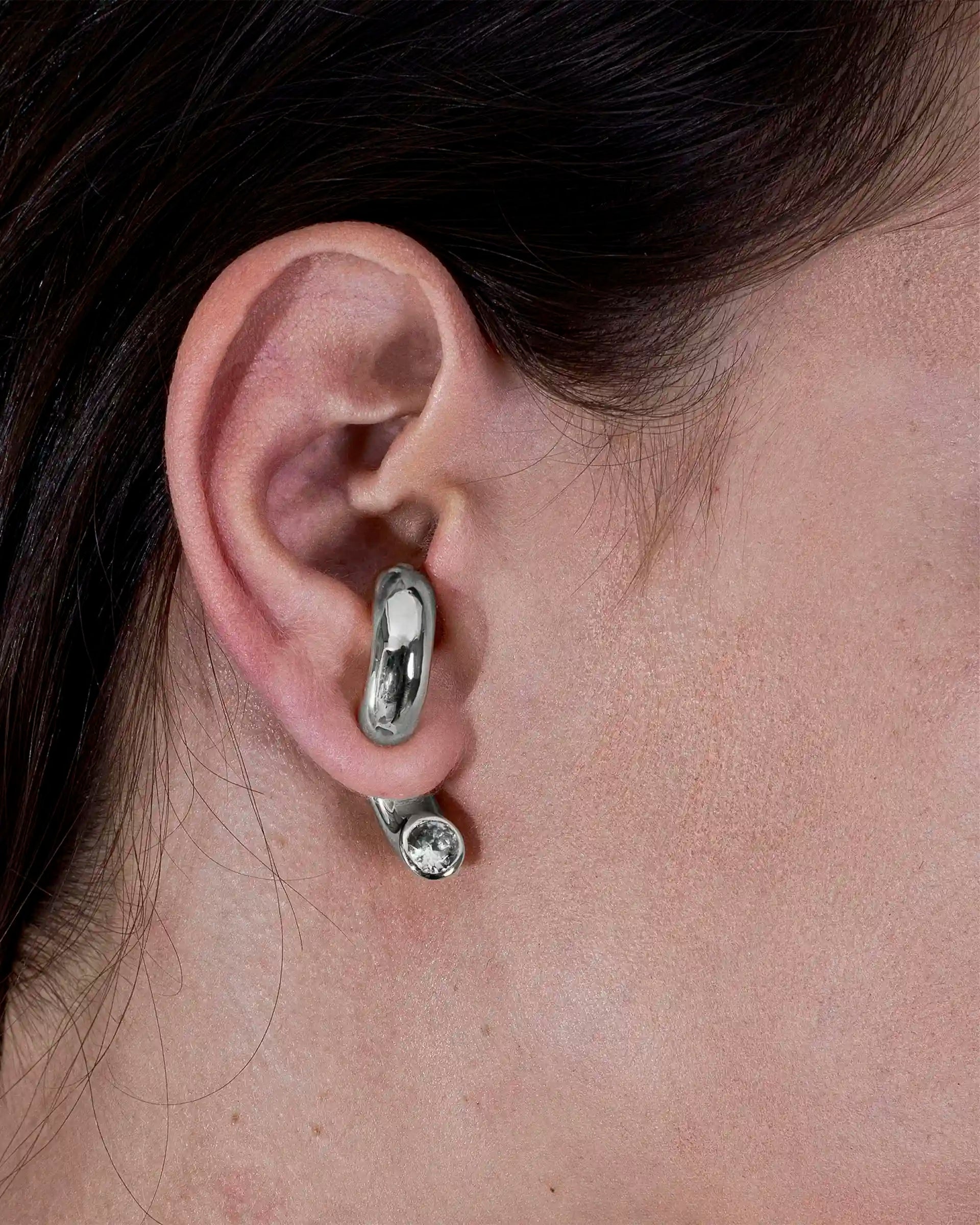 Alan Crocetti Clear Blown Peekaboo single earring in silver with zirconia stone on model.