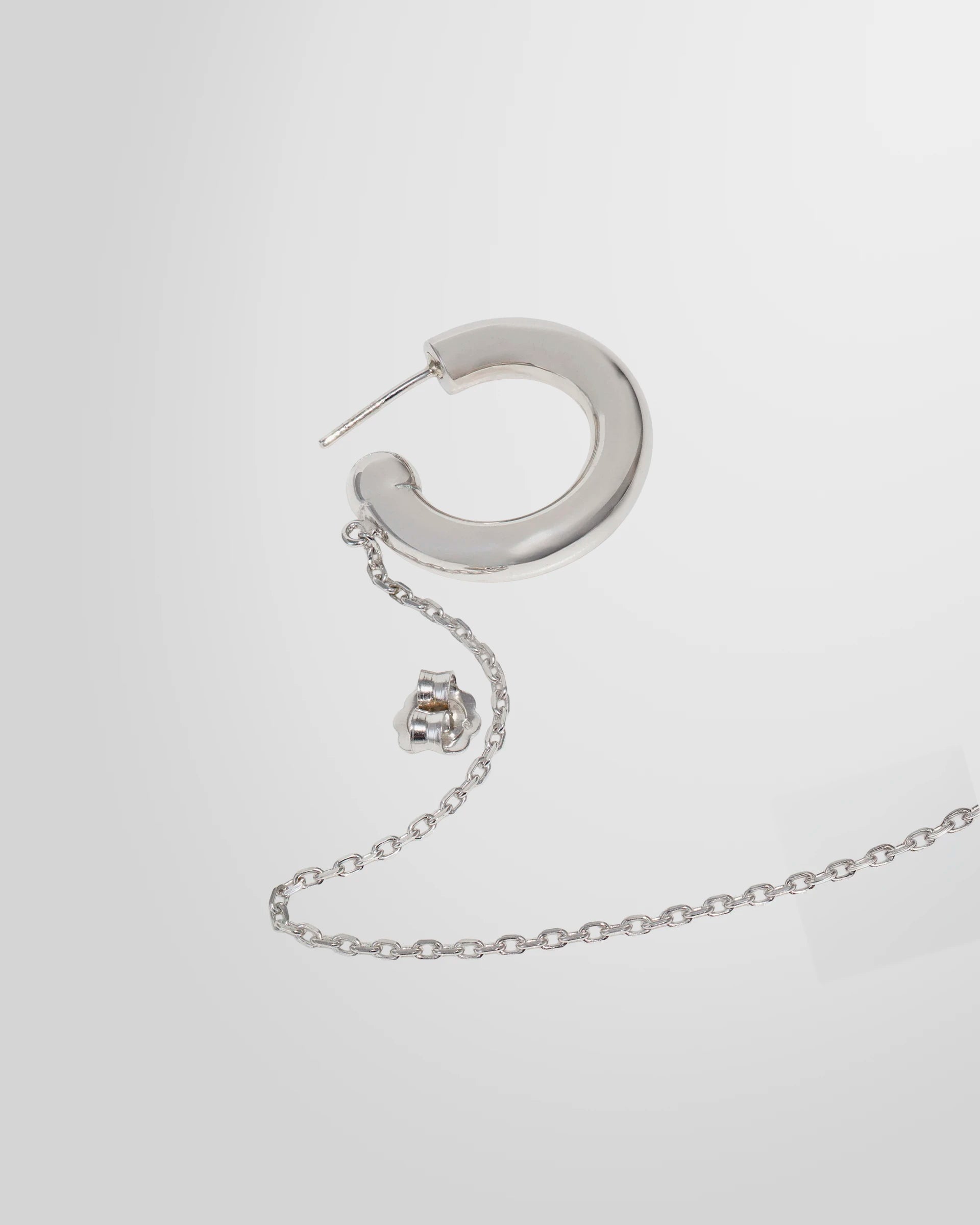 Detail of the Alan Crocetti Mood Ear Set earring highlighting the rhodium finish and chain attachment.