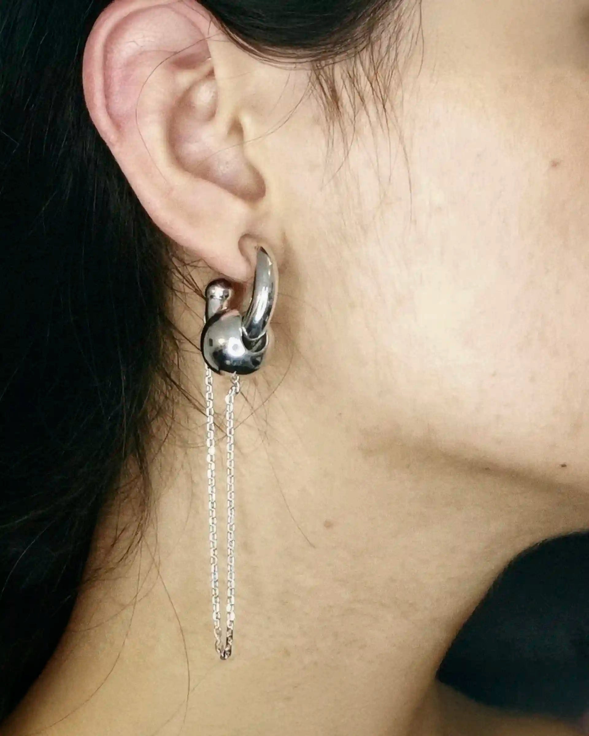 Angle view of a model wearing the Alan Crocetti Mood Ear Set earring in silver.