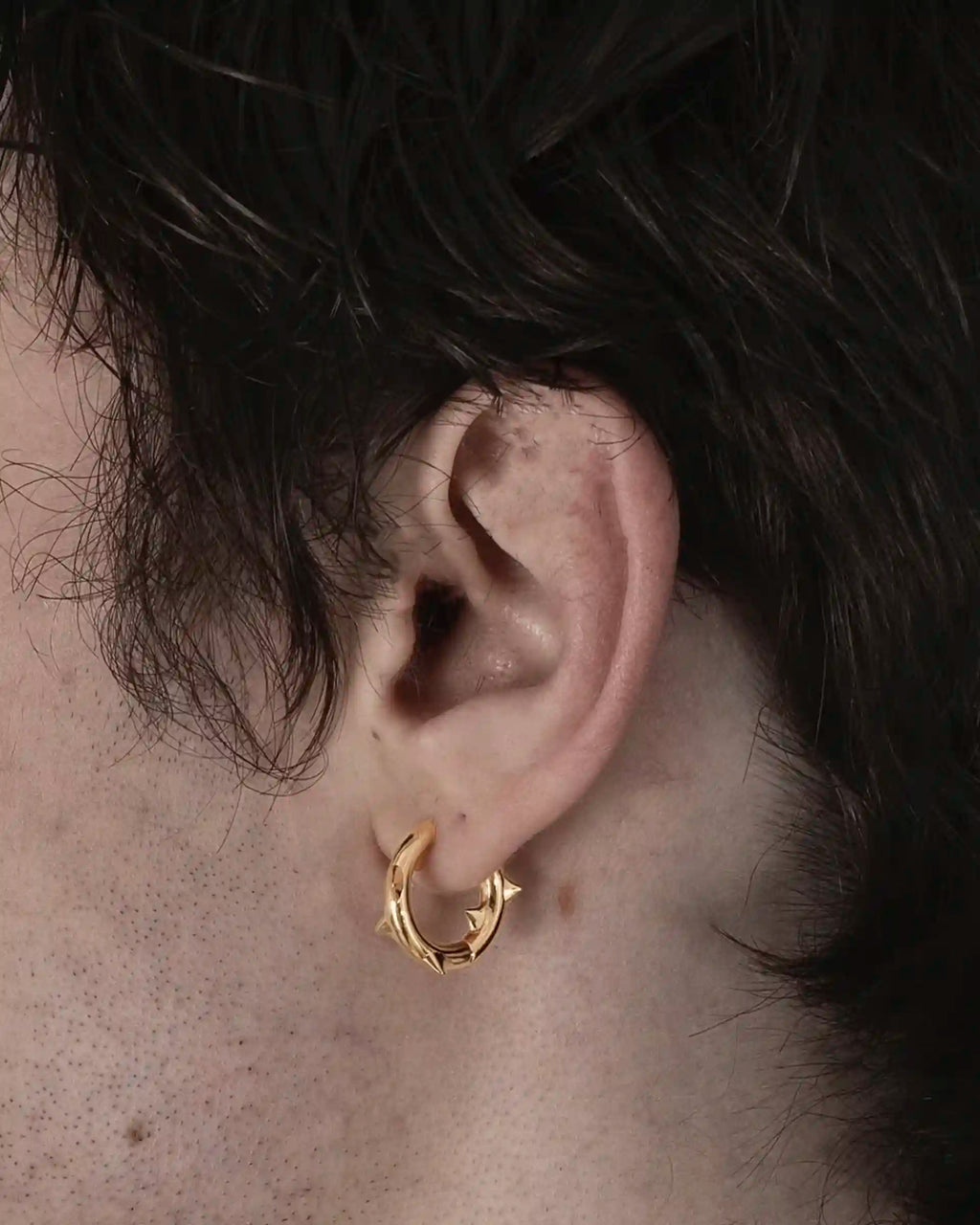 Model wearing the single Alan Crocetti Peekaboo Thorn Earring in gold vermeil.