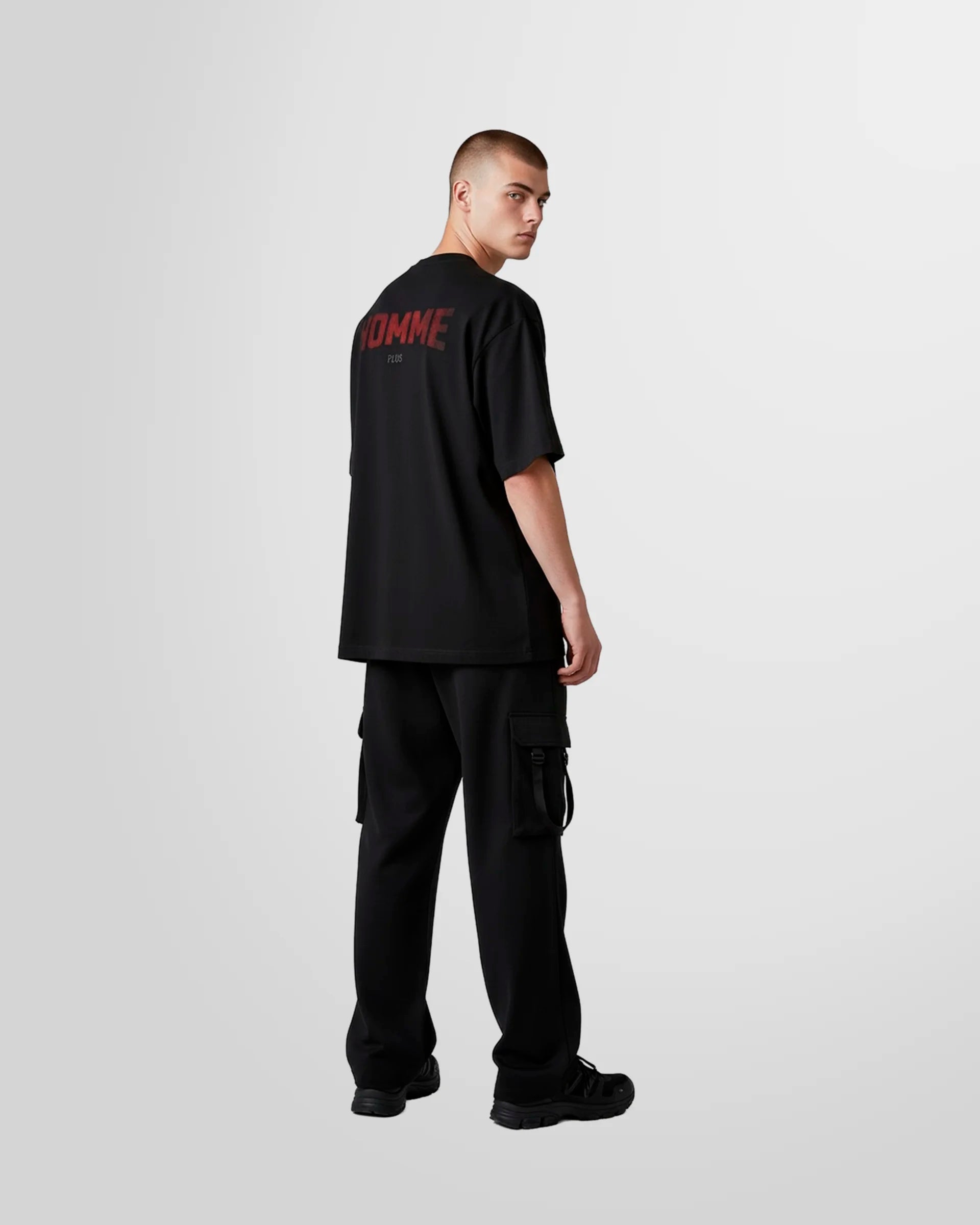 Back view of the model wearing the Black Initial T-shirt by Not Guilty Homme showcasing the red print on the back.