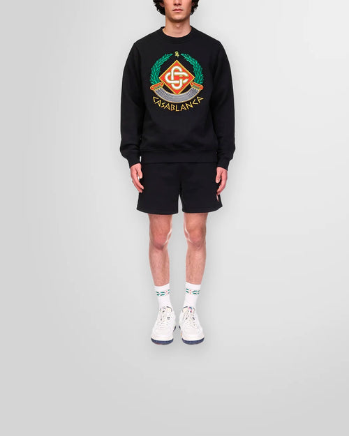 Lifestyle image of the Casa Crest Sweatshirt paired with black cotton shorts.