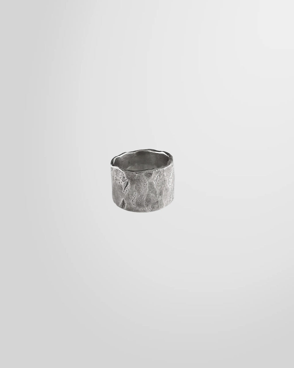 Front view of the Johnny Ramli Forged Band Ring in oxidised sterling silver, showing its irregular shape.