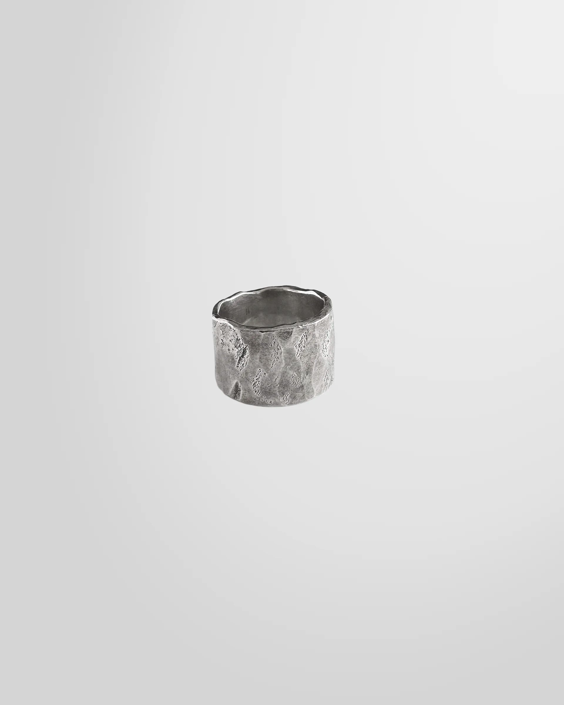 Front view of the Johnny Ramli Forged Band Ring in oxidised sterling silver, showing its irregular shape.