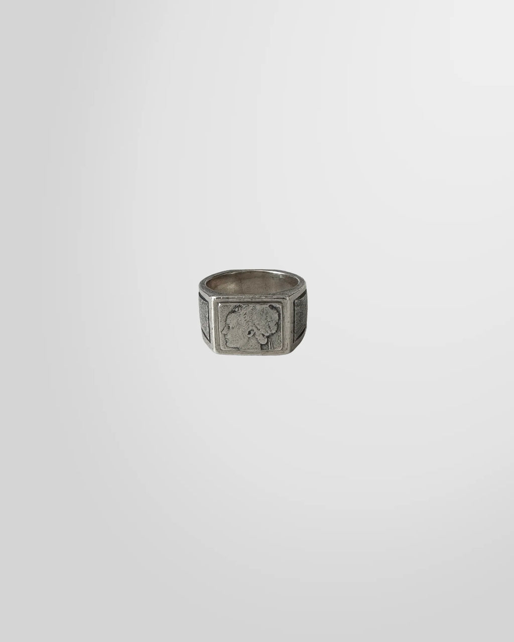 Top-down view of the Johnny Ramli silver signet ring, showing the engraved classical portrait on the square face.