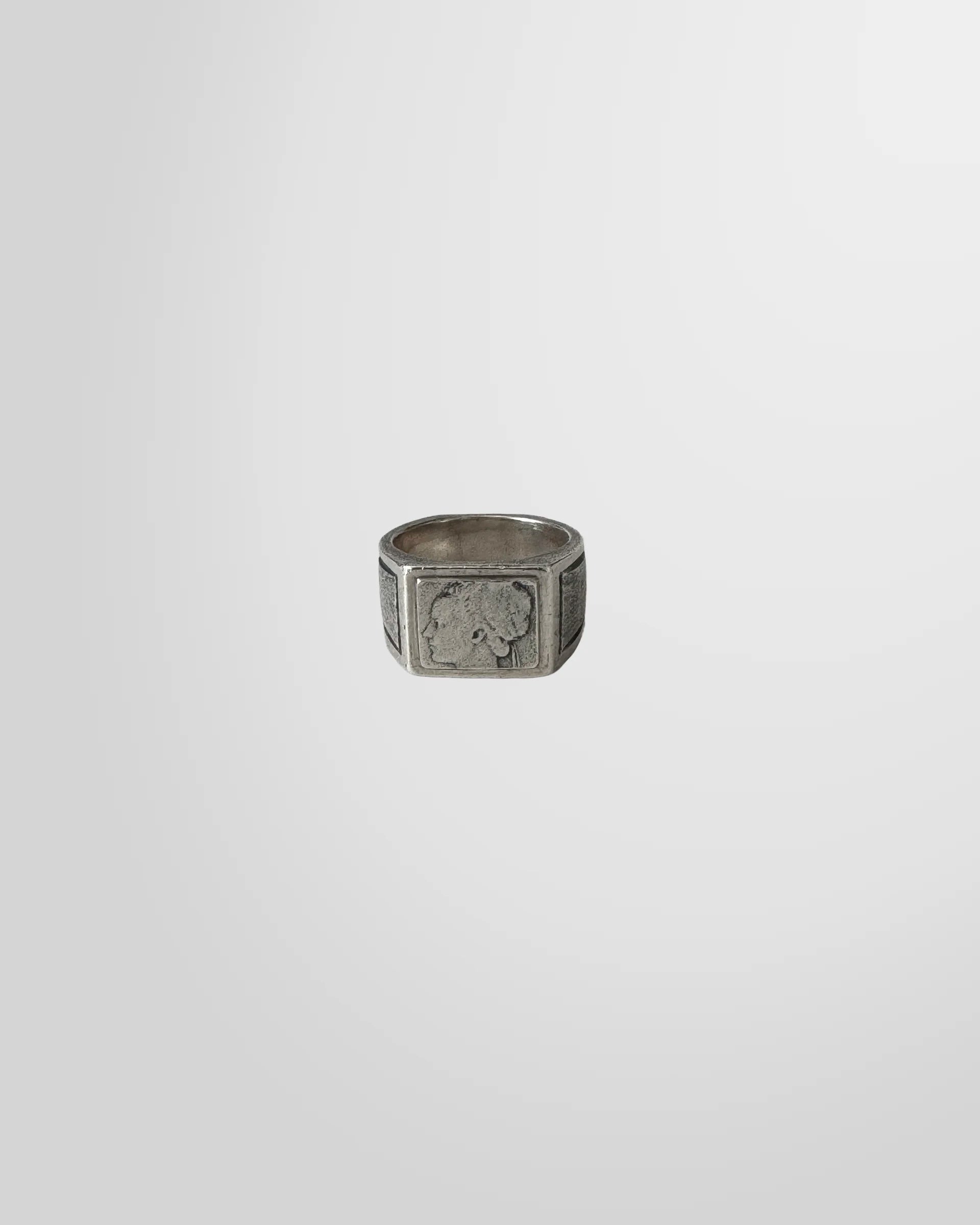 Top-down view of the Johnny Ramli silver signet ring, showing the engraved classical portrait on the square face.