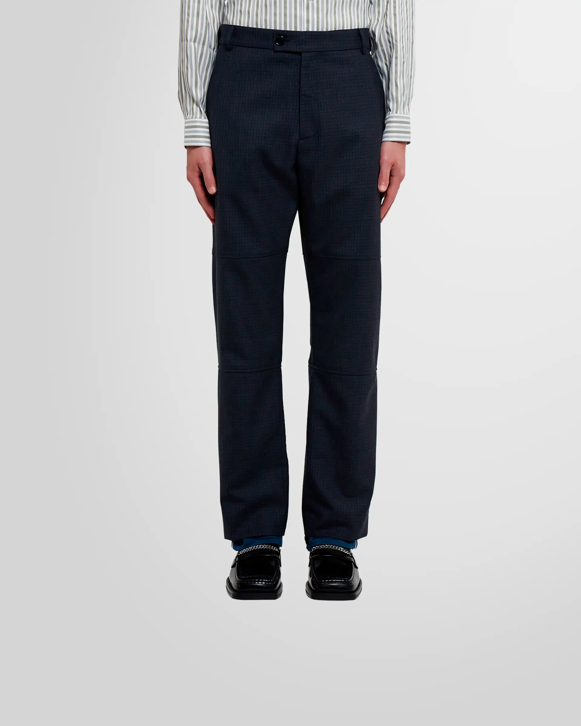 Front view of a model wearing Martine Rose Sports Hem Trousers in navy check, showcasing the fit.