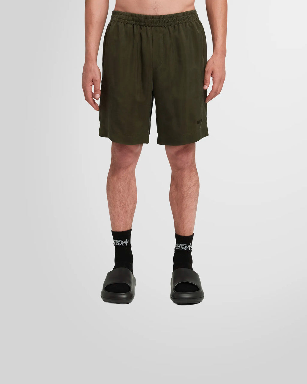 Model wearing the MSGM Cupro Shorts in military green, showcasing the relaxed silhouette.