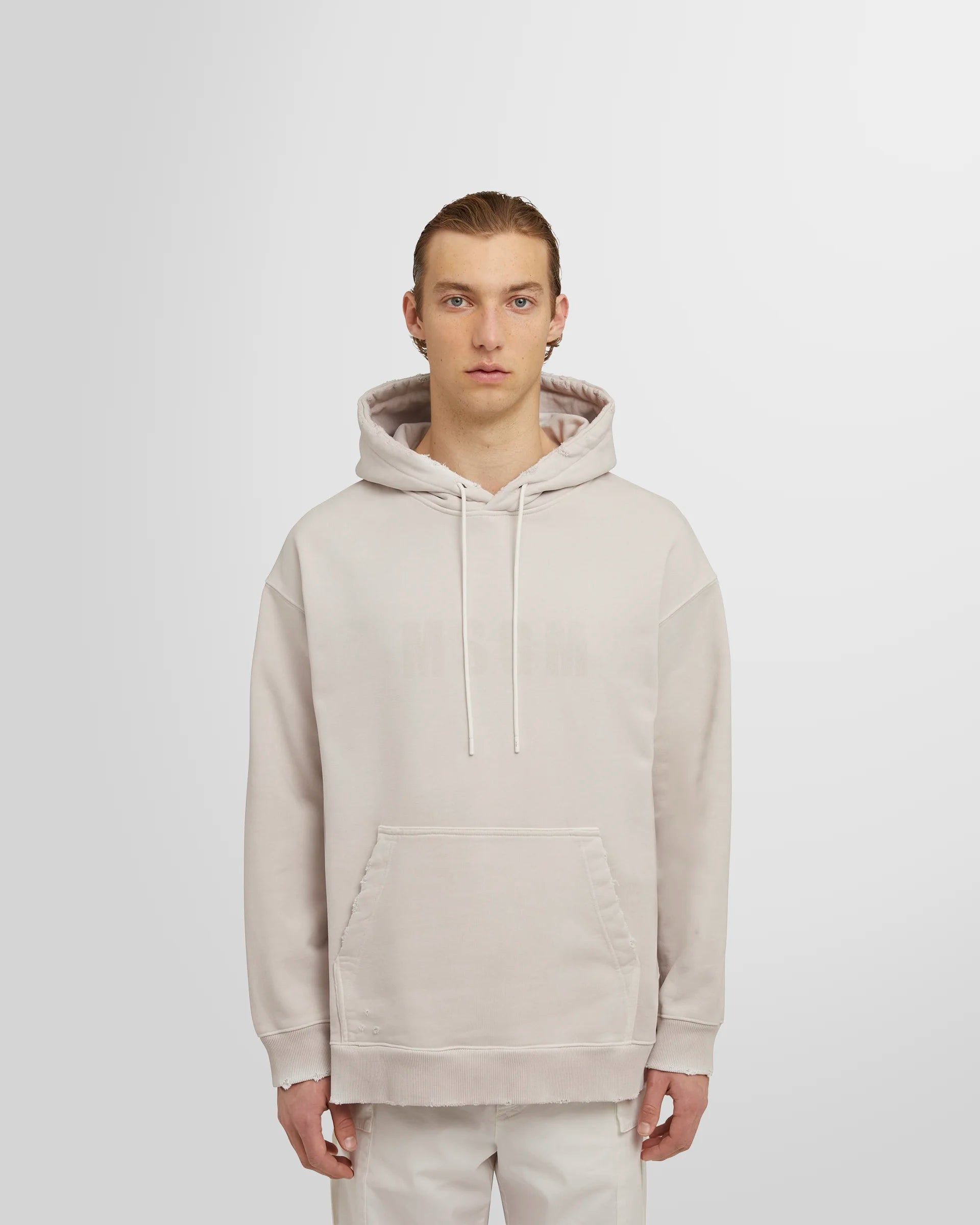 Model wearing the ash grey MSGM Distressed Logo Hoodie.