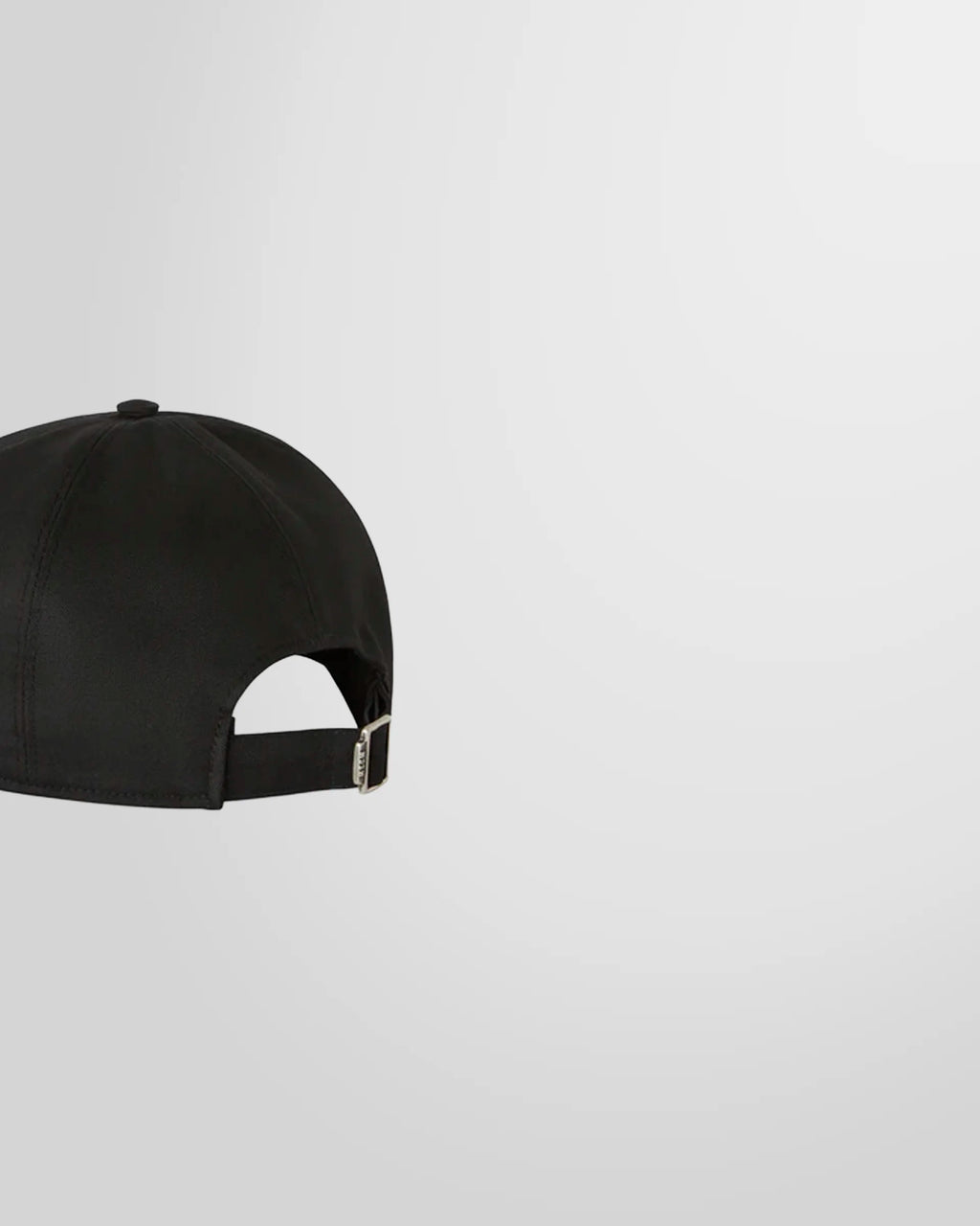 Side view of the black MSGM baseball cap showing the curved peak and adjustable buckle.