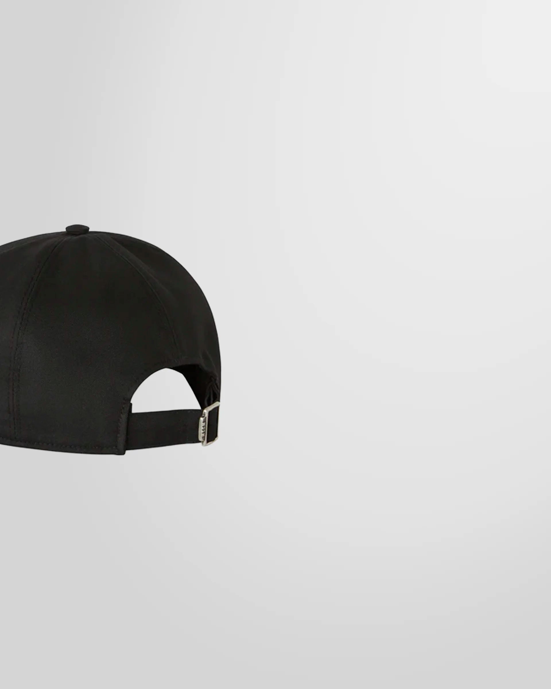 Side view of the black MSGM baseball cap showing the curved peak and adjustable buckle.