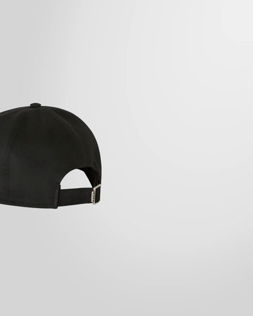 Side view of the black MSGM baseball cap showing the curved peak and adjustable buckle.