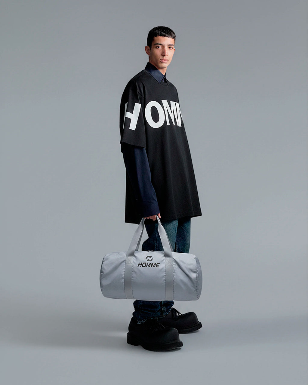 Model carrying the Not Guilty Homme sport bag, demonstrating its scale and function as a modern gym accessory.