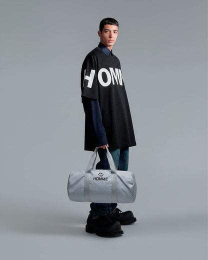 Model carrying the Not Guilty Homme sport bag, demonstrating its scale and function as a modern gym accessory.