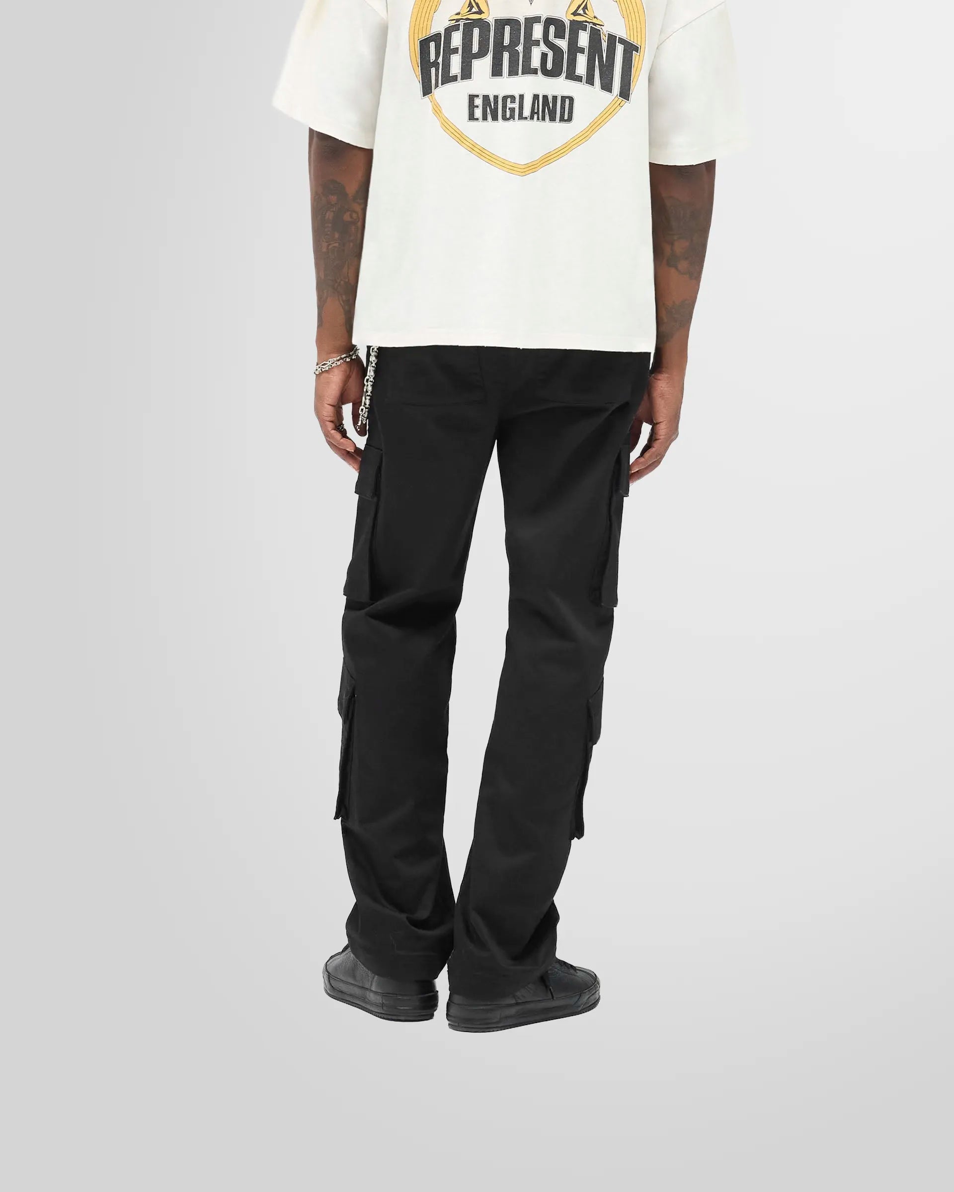 Back view of a model wearing the Represent Cargo Pant in jet black.