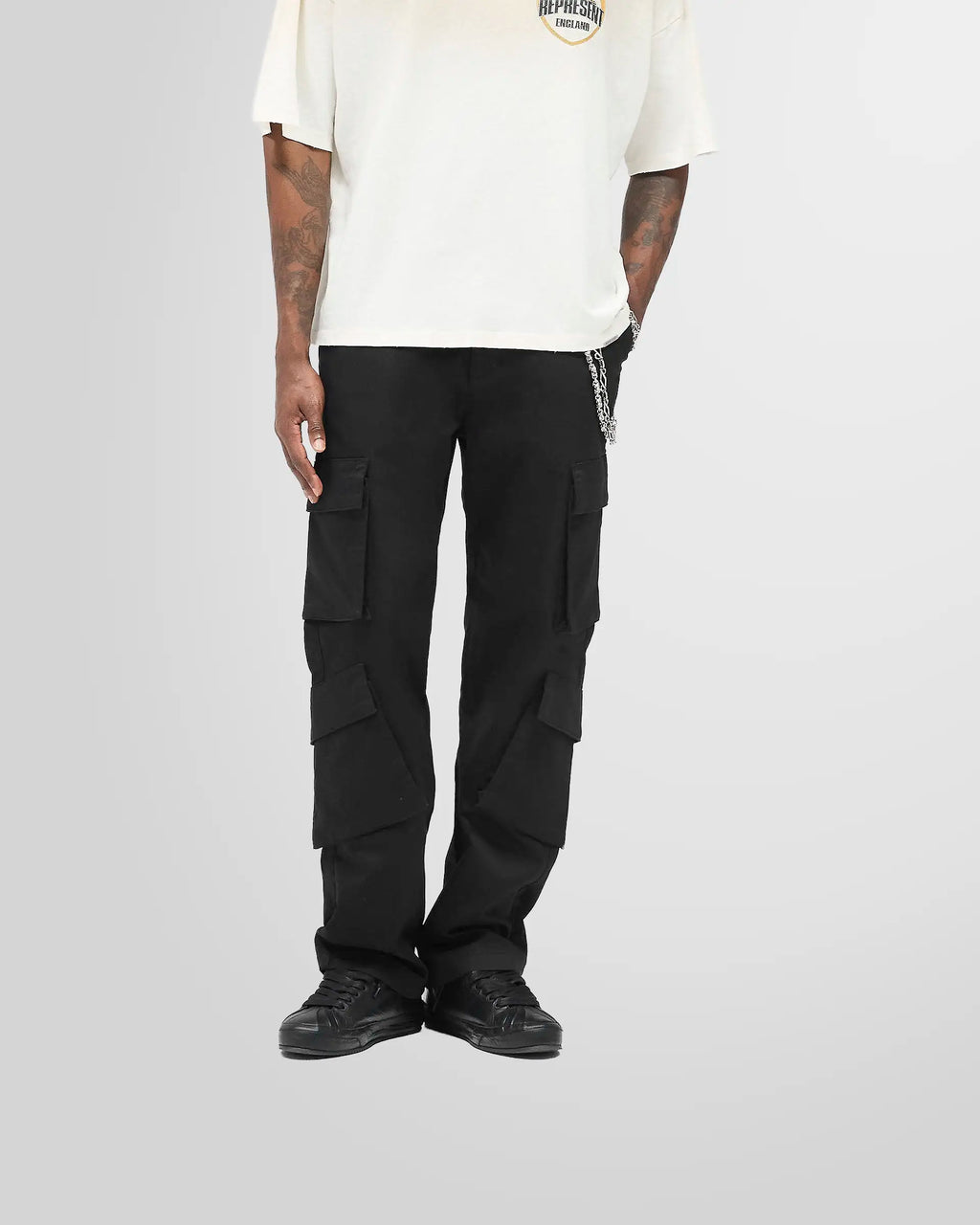 Model wearing the Represent Cargo Pant in jet black, showing the silhouette and fit from a front view.