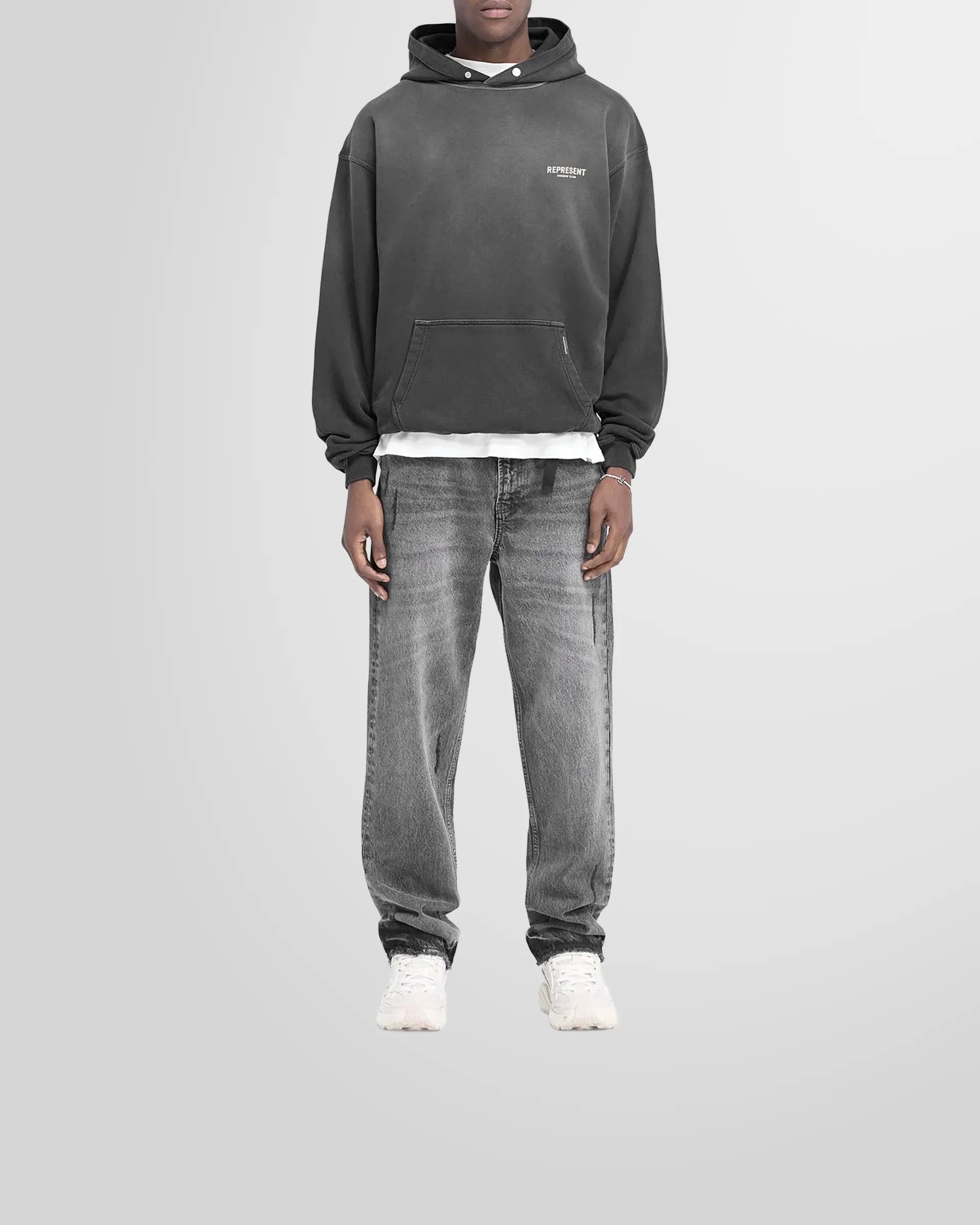 Model wearing the oversized Represent Owners' Club Hoodie in aged black.