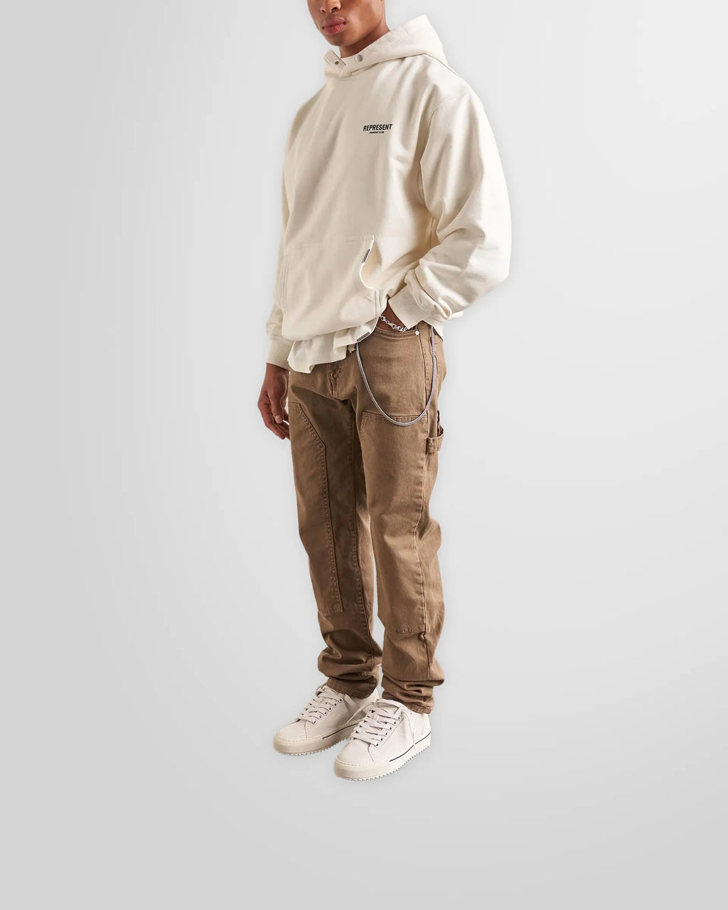 Model wearing the oversized Represent Owners' Club Hoodie in Flat White.