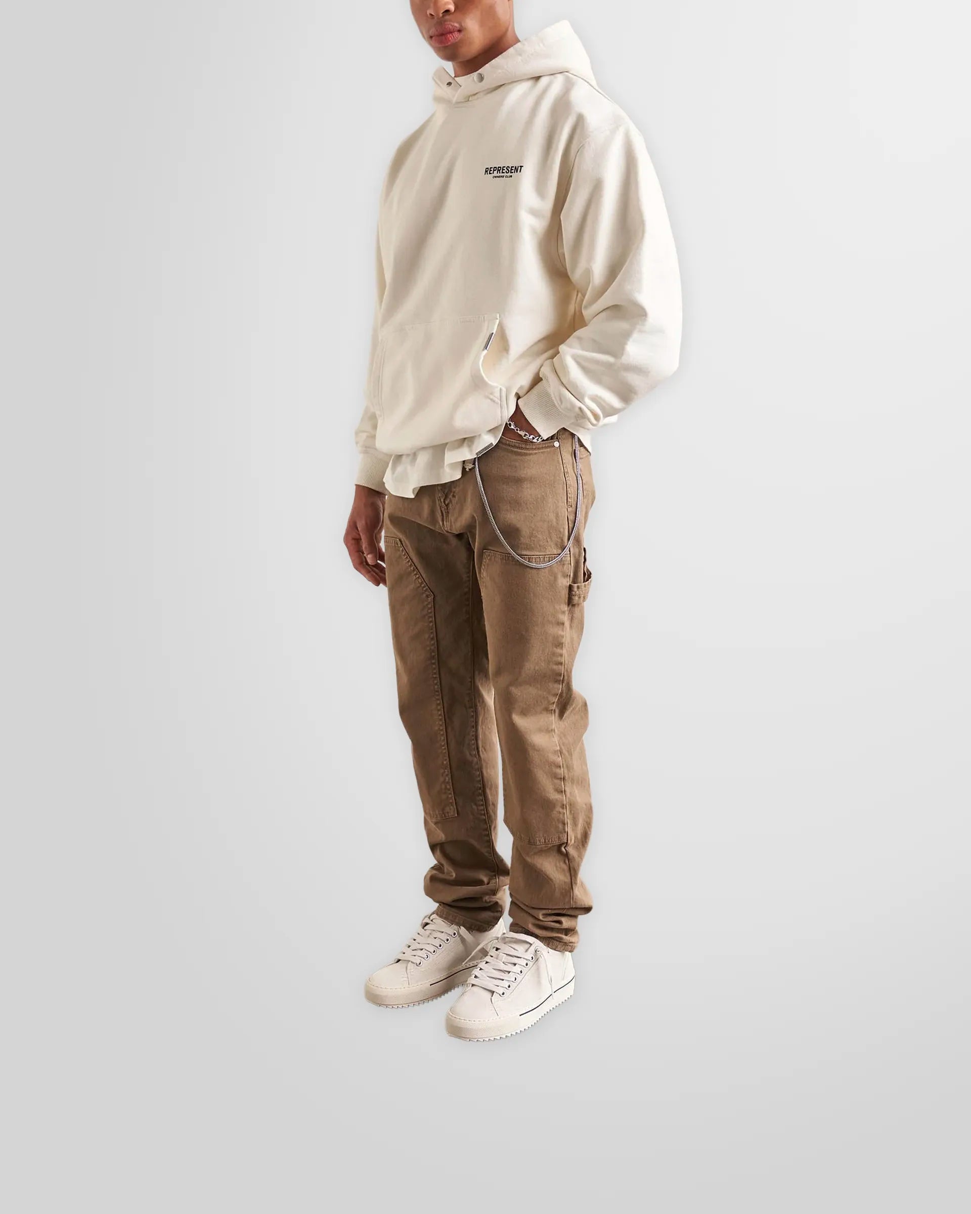 Model wearing the oversized Represent Owners' Club Hoodie in Flat White.