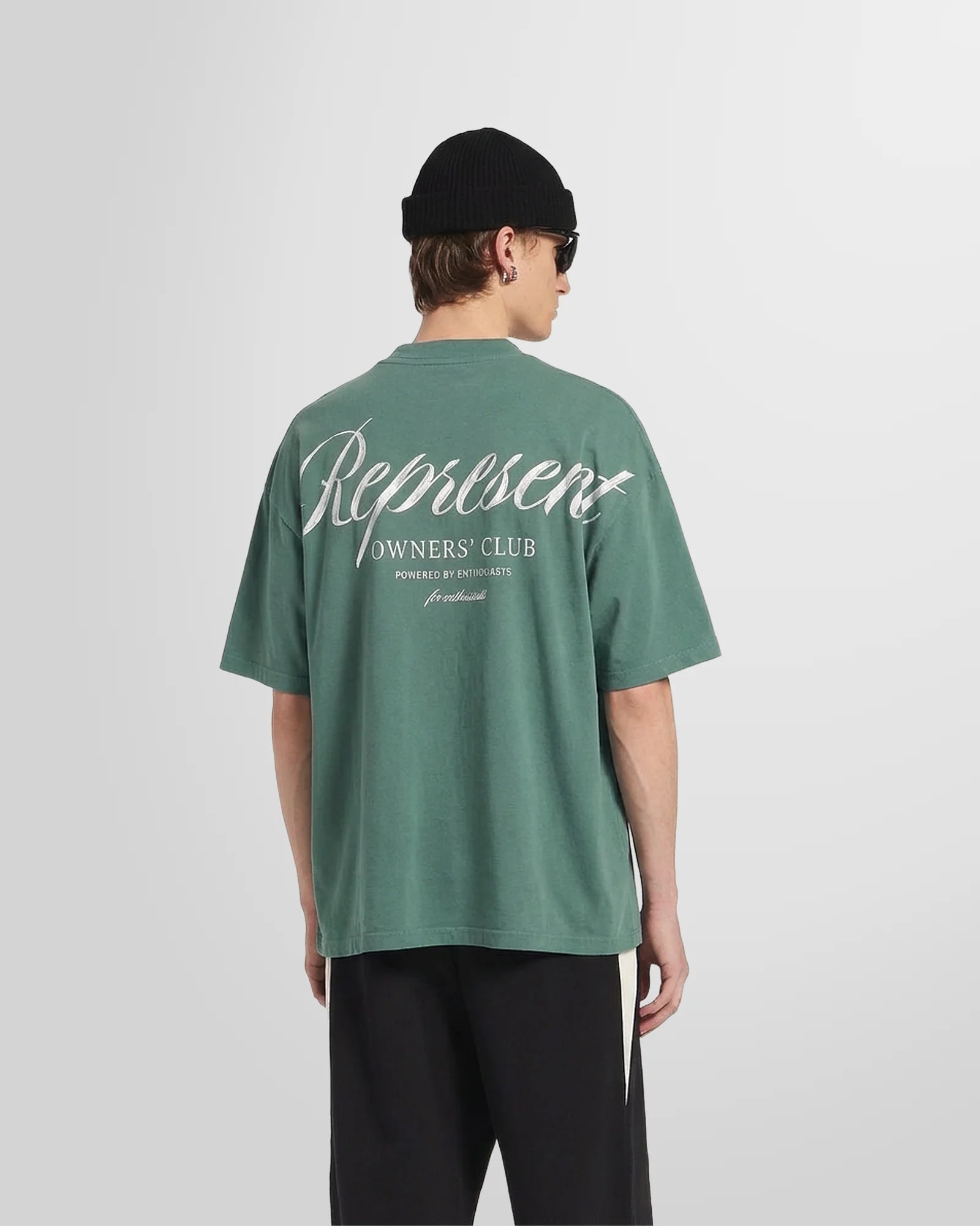 Back view of a model wearing the Owners’ Club script print with brushed effect in vintage green.