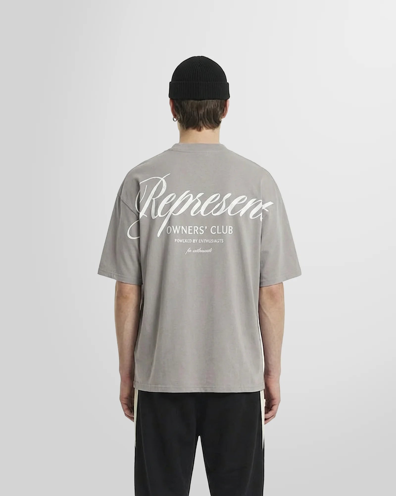 Back view of a model wearing the Represent Owners Club Script T-Shirt, displaying the large script branding in slate.