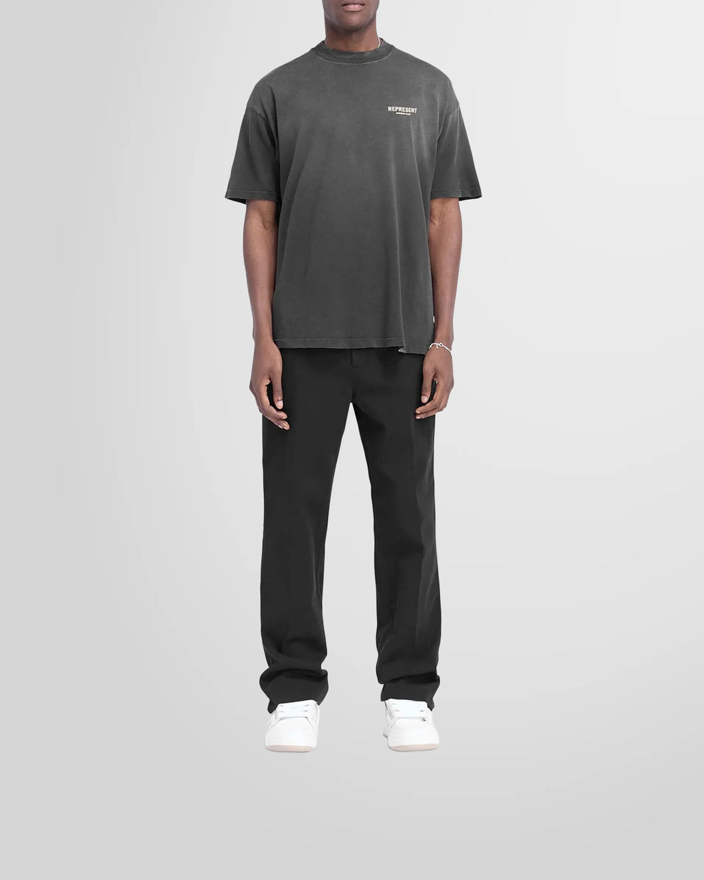 Model wearing the slightly oversized Represent Owners Club T-Shirt in aged black.