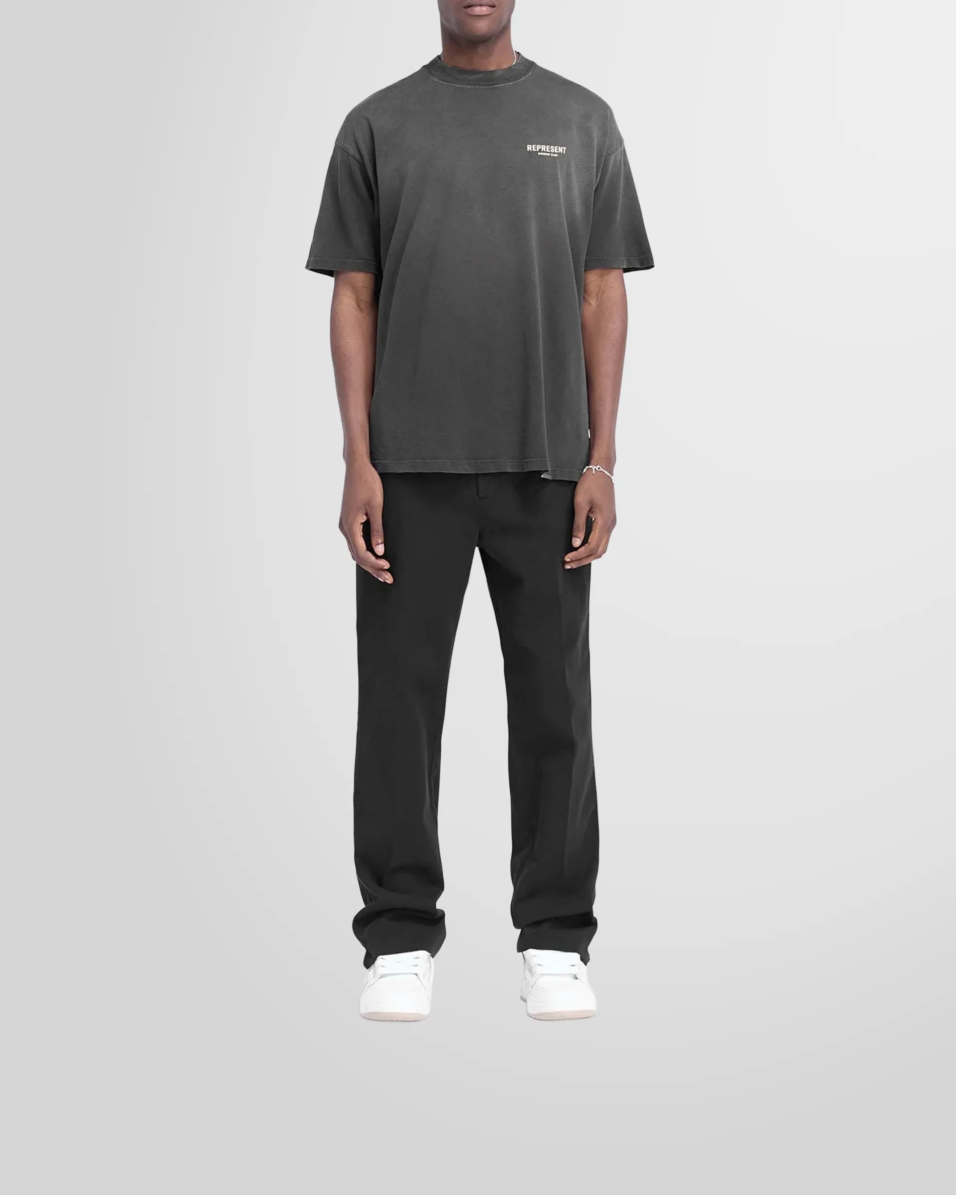 Model wearing the slightly oversized Represent Owners Club T-Shirt in aged black.