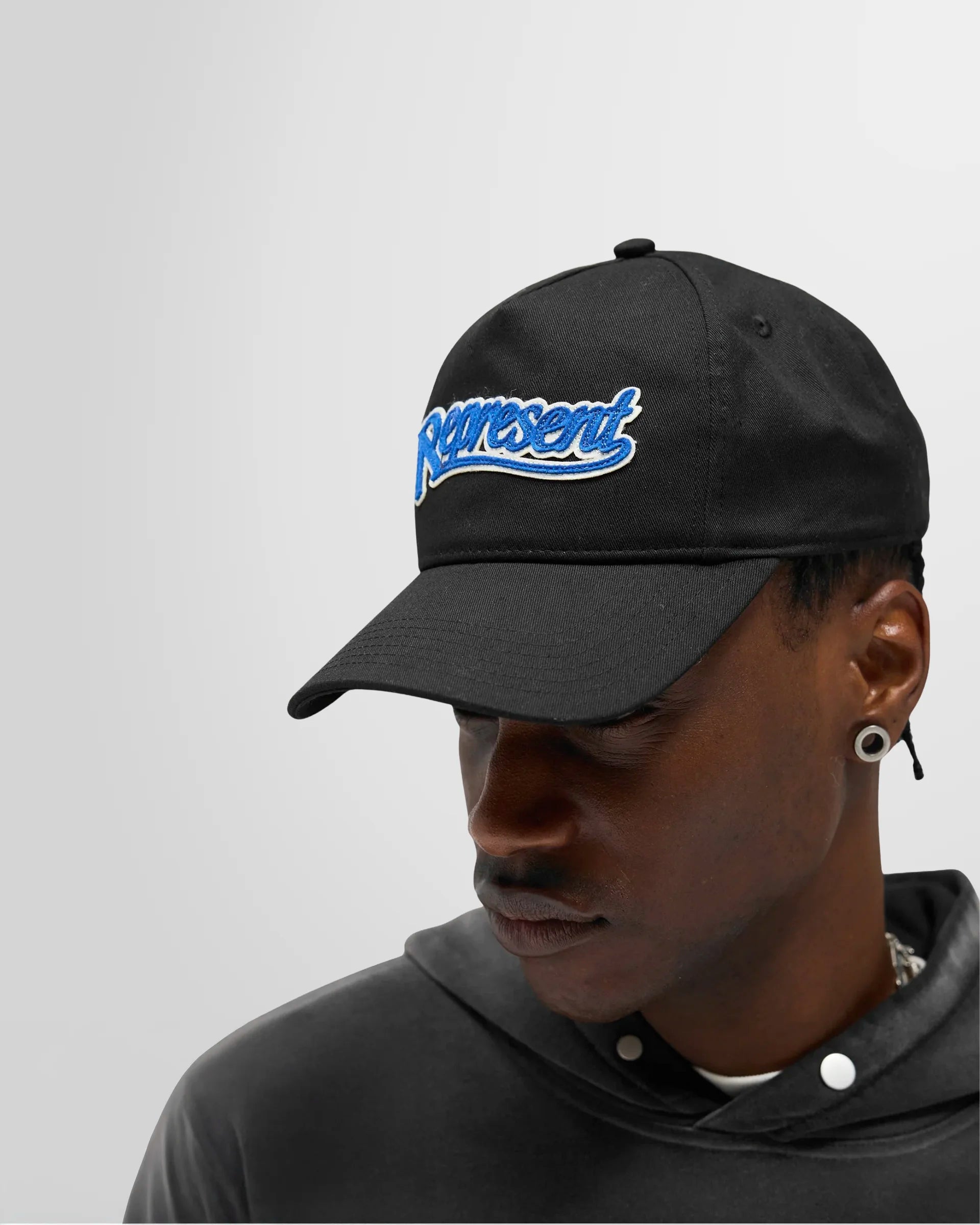 Model wearing the Represent Showcasing Cap to demonstrate its fit and style.
