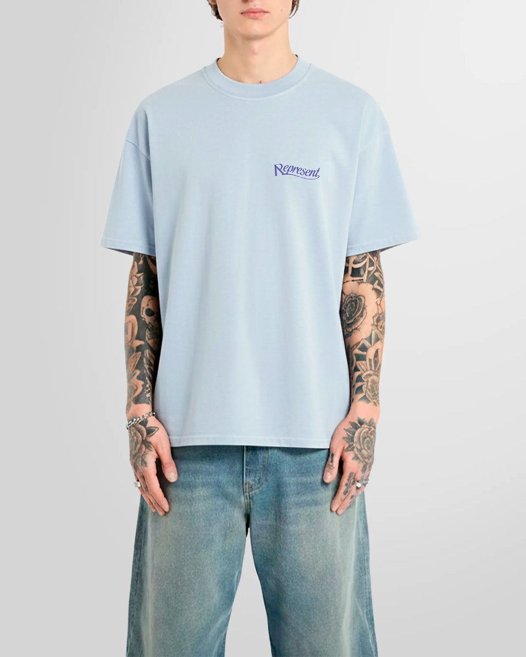 Model wearing the Represent Showcasing T‑Shirt in Cloud with small script logo at chest.