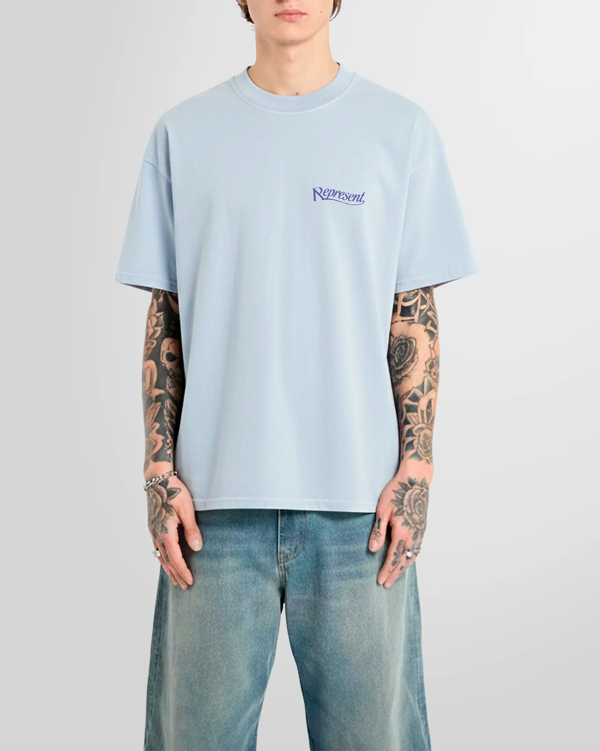 Model wearing the Represent Showcasing T‑Shirt in Cloud with small script logo at chest.