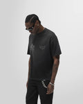 Model wearing the aged black Thoroughbred tee, front view, oversized fit.