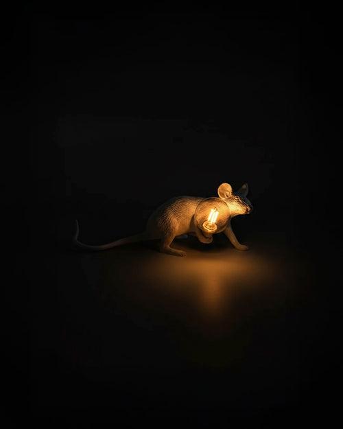 The Seletti Mouse Lamp in a night view, highlighting the light bulb it holds.