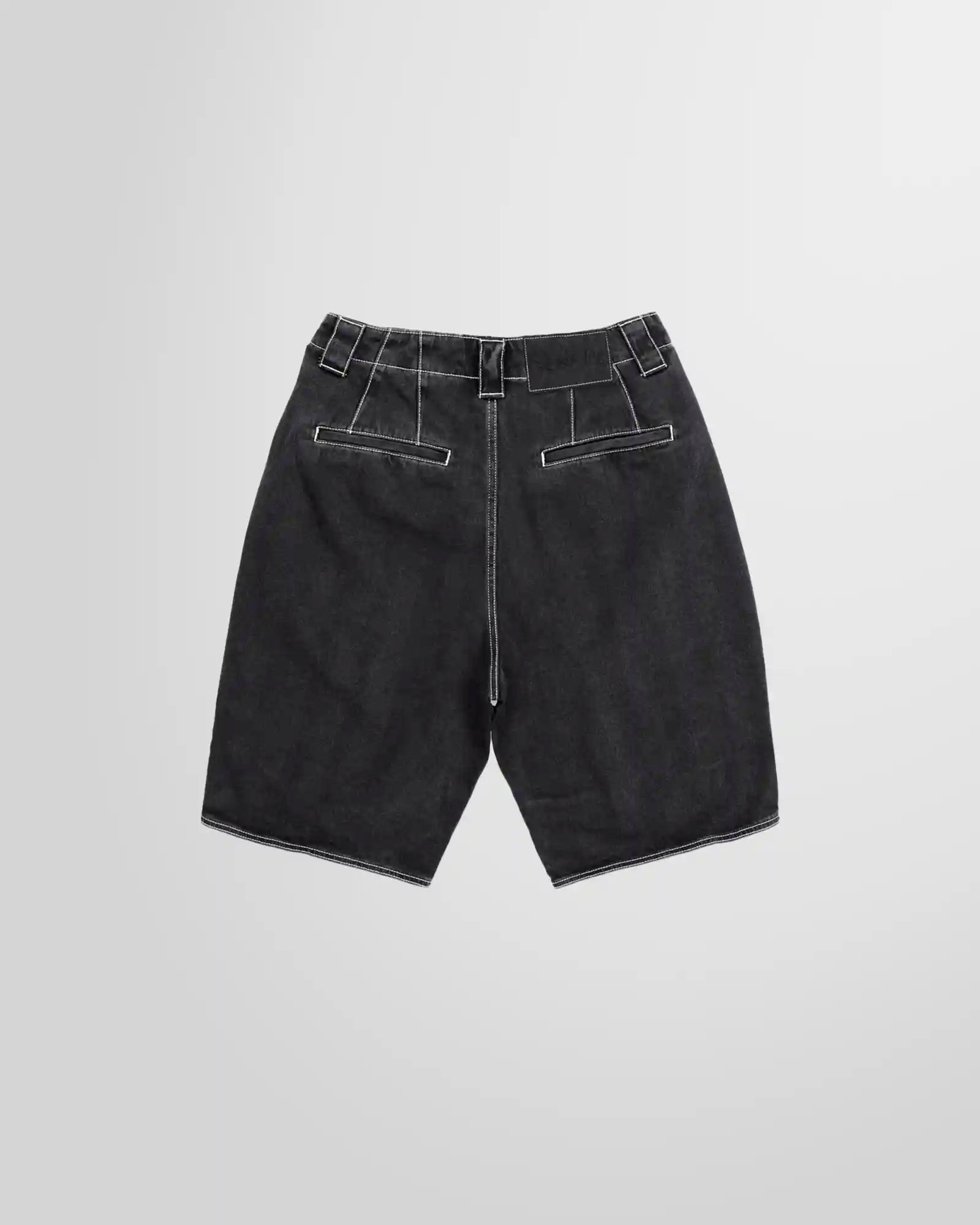 Studio photograph showing the back of the denim shorts from Sunnei in washed black with contrasting white stitching.